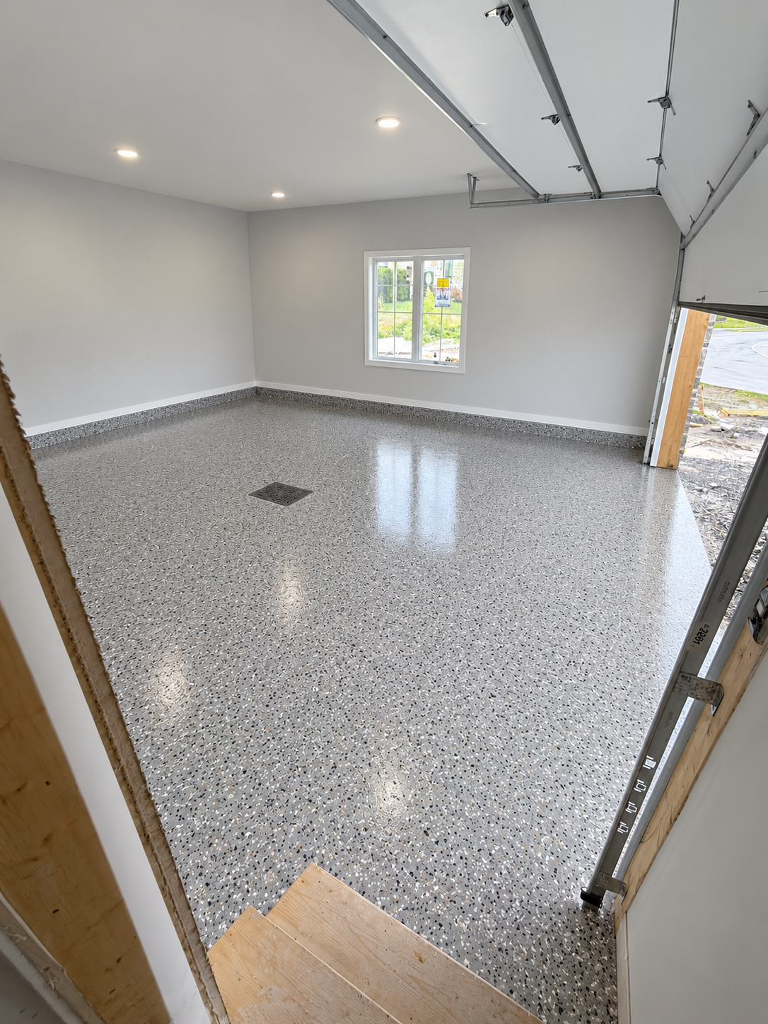 Plancher d'époxy à flocons gris avec drain de plancher